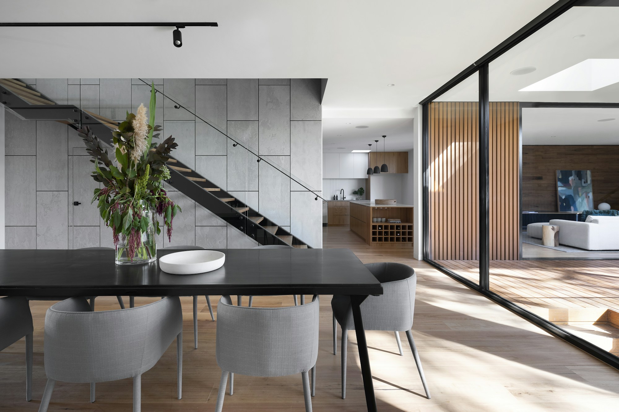Elegant modern home with warm timber floors, grey dining chairs and sunlit living spaces